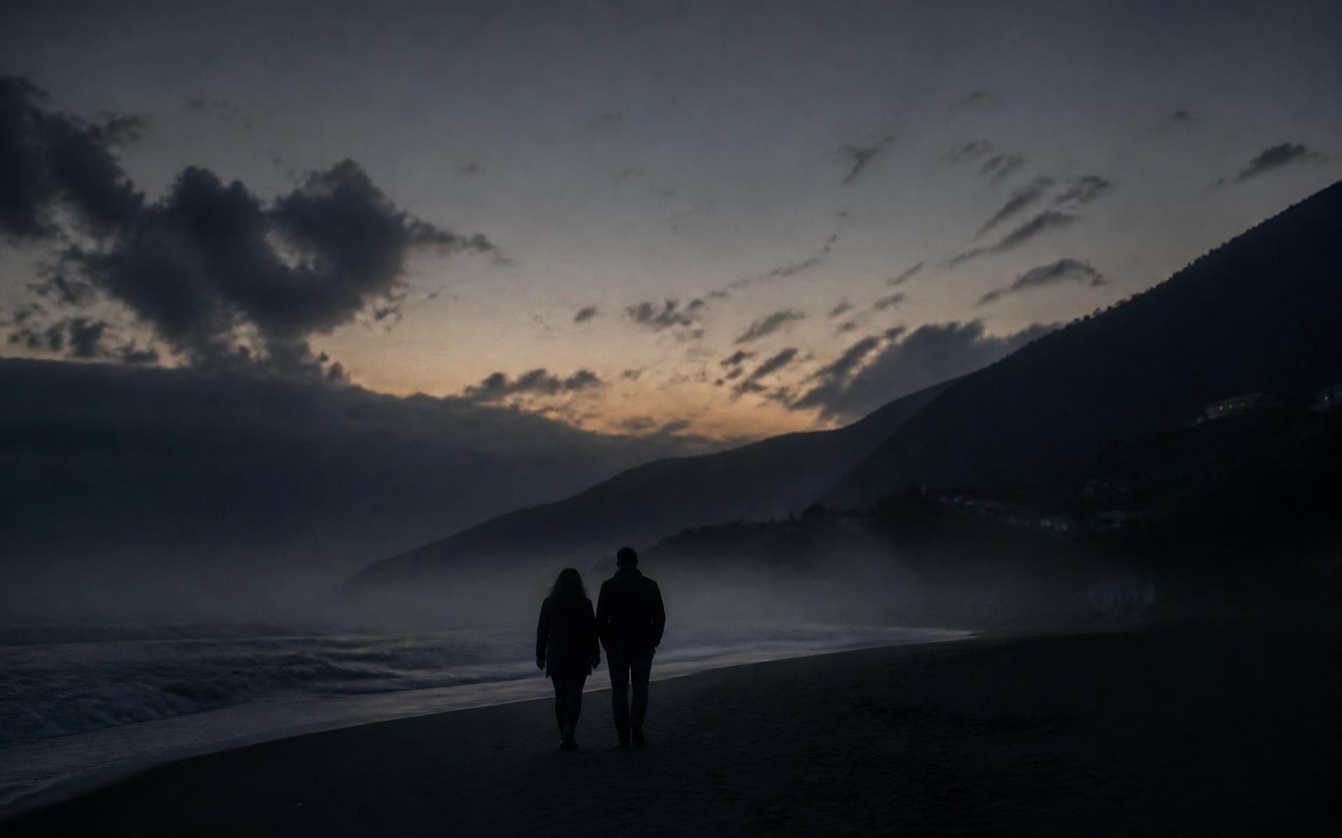 Couple silhouetted on a quiet beach at dusk in Georgia